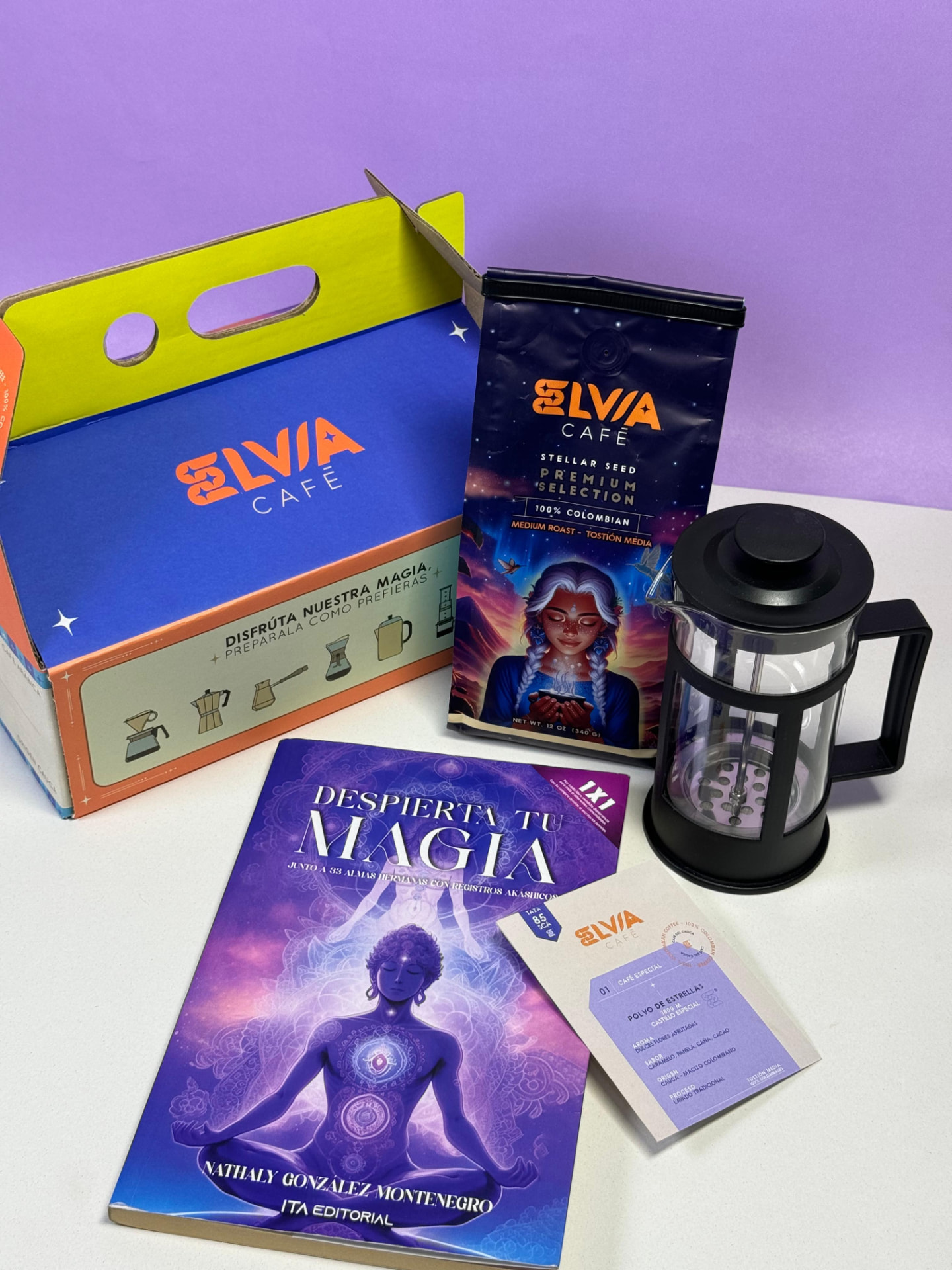Kit de regalo Elvia Café con caja turquesa, bolsa de café, libro Despierta tu Magia, prensa francesa y postal sobre fondo morado